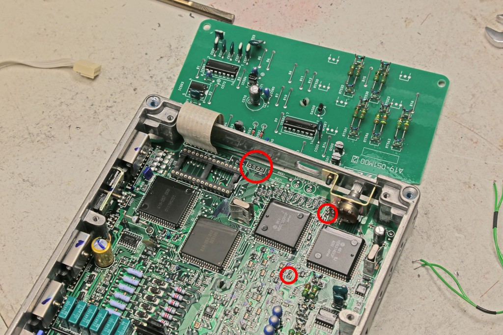 The upper circle is where the ribbon cable installs on the Nistune Daughterboard, the two on the right are where the diagnostics selector wires used to connect.